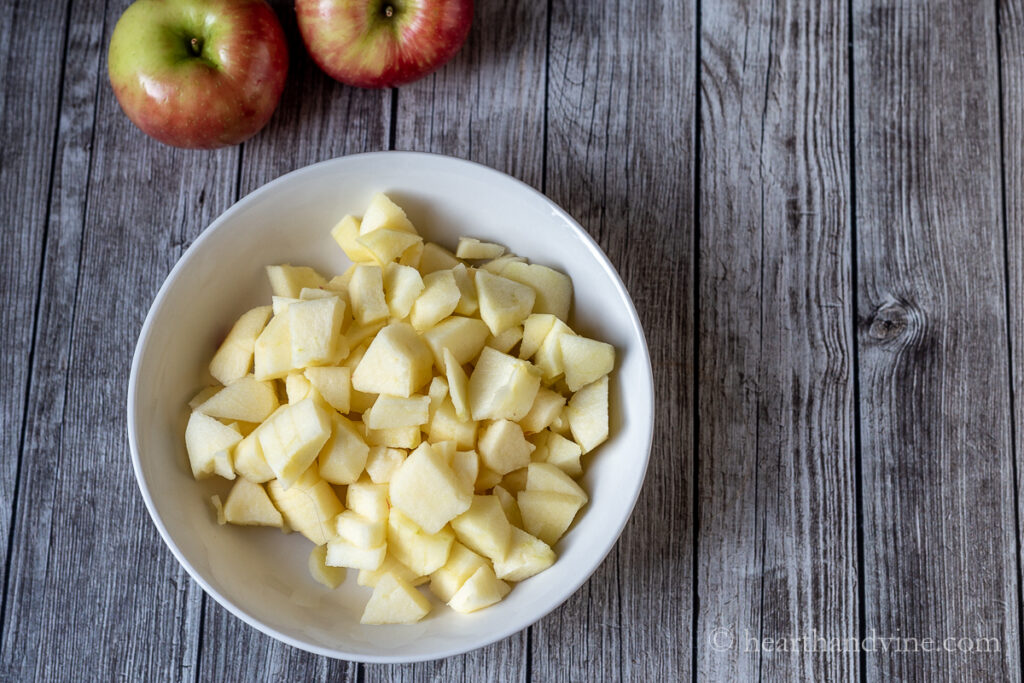 A bowl of peeled, sliced and cut up apples.