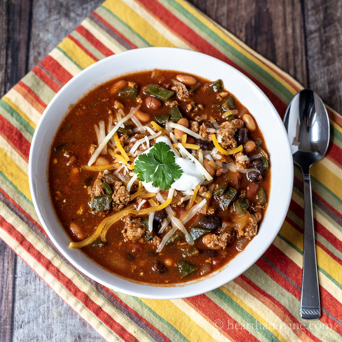 Bowl of ground turkey chili with poblano peppers.