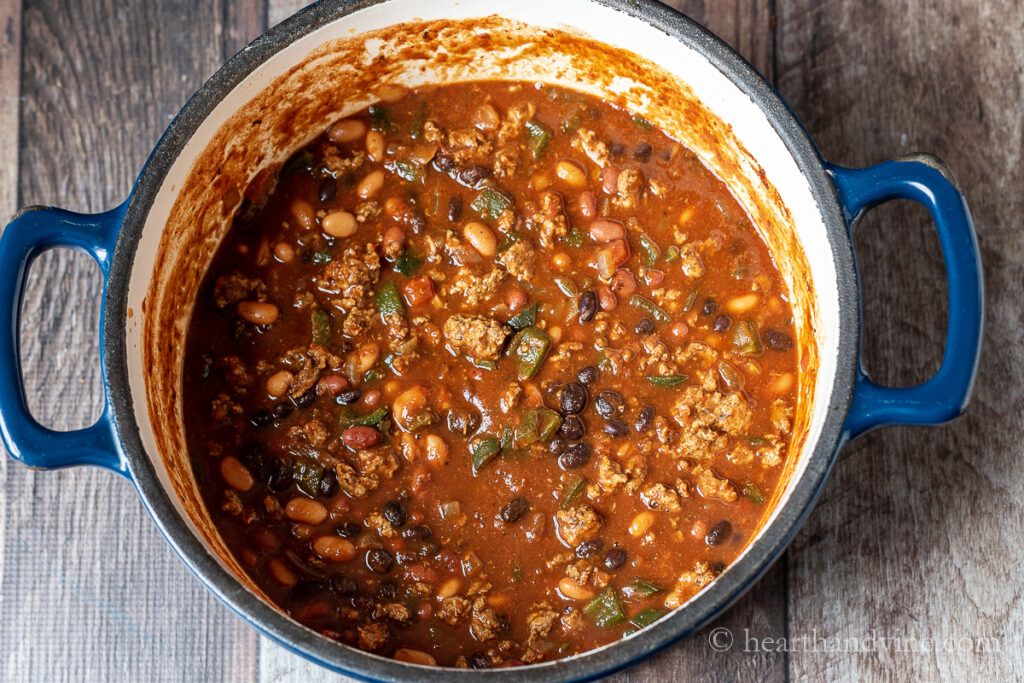 Large pot of turkey chili with poblano peppers, three types of beans and crushed tomatoes.