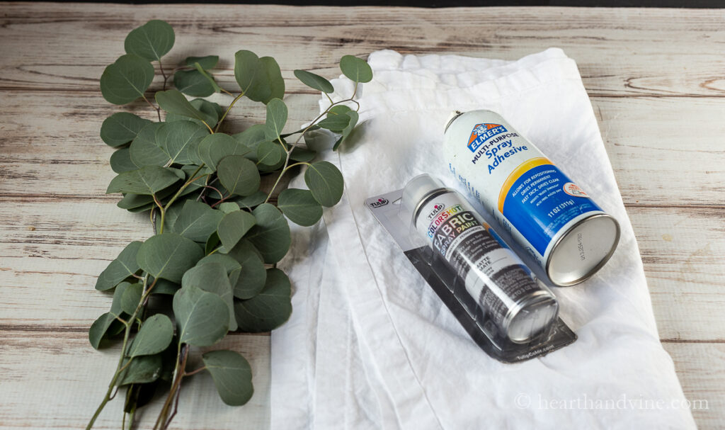 Silver dollar eucalyptus branches, white napkins, gray fabric spray paint and spray adhesive.