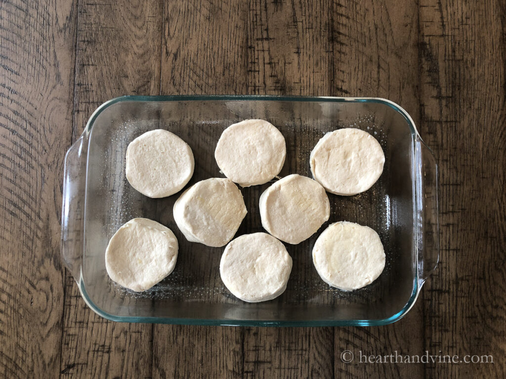 Casserole baking dish with eight biscuit on the bottom.