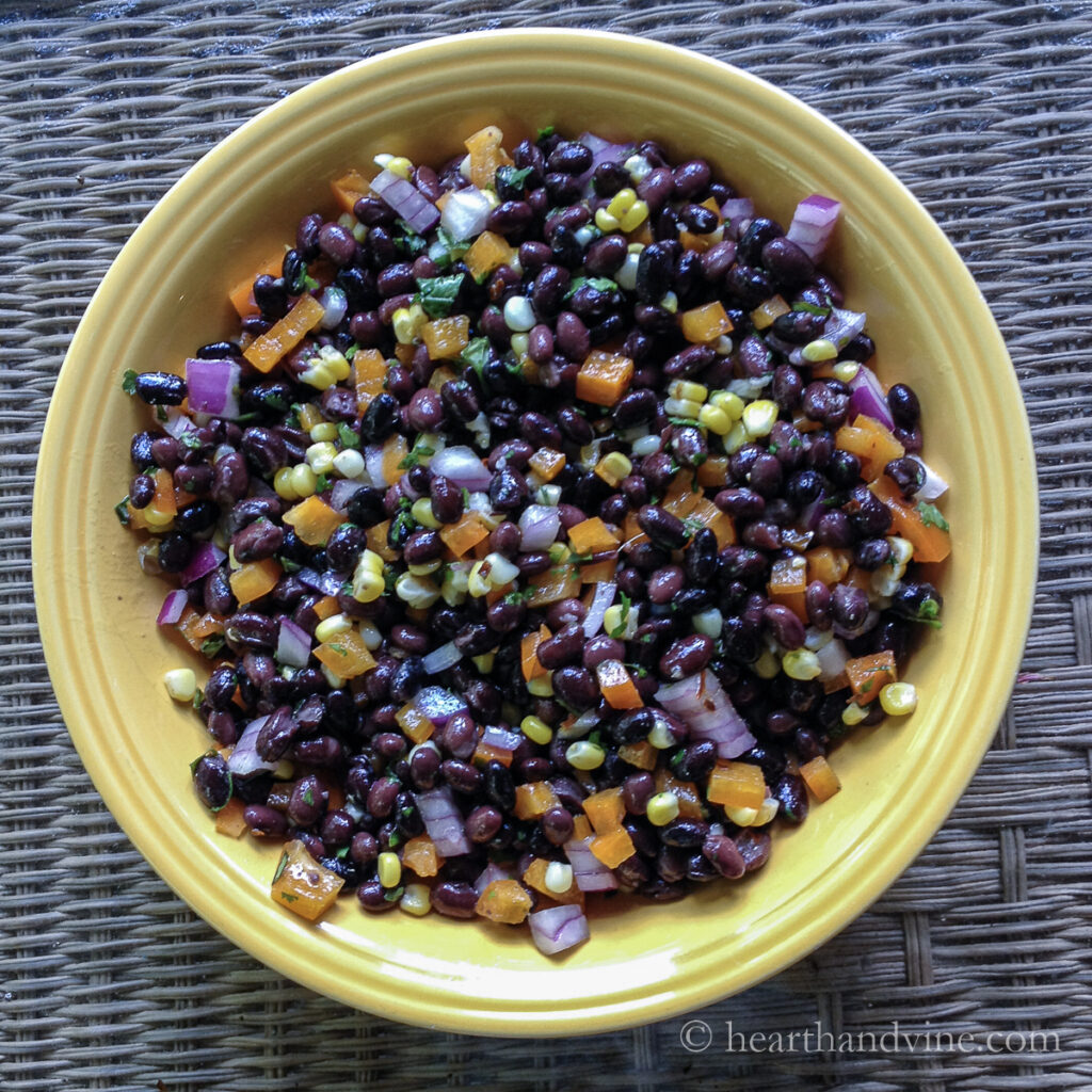 Large yellow bowl fill with southwest black bean salad.