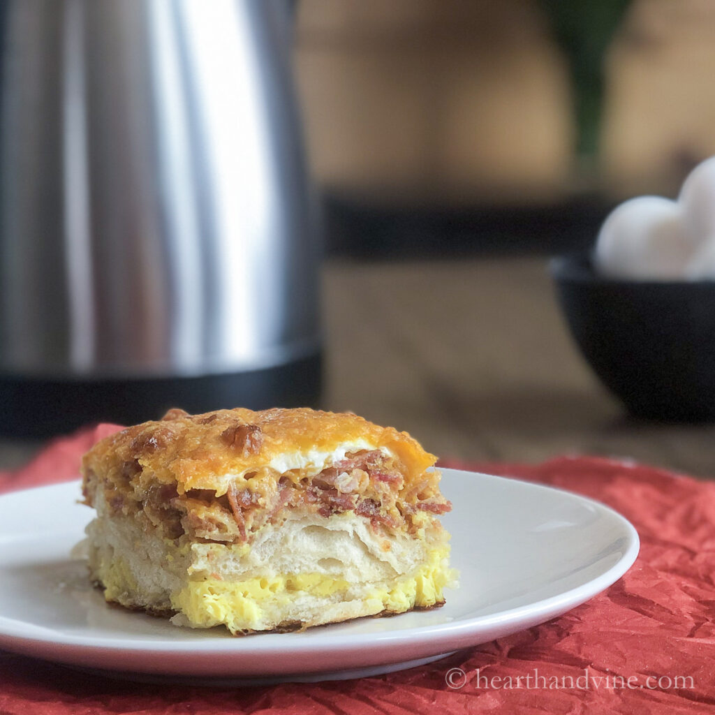 Serving of breakfast casserole with biscuits, bacon and cheese.