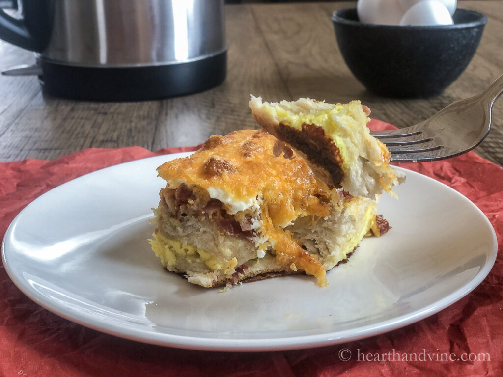 Breakfast bake with biscuits serving and a forkful lifting a bite.