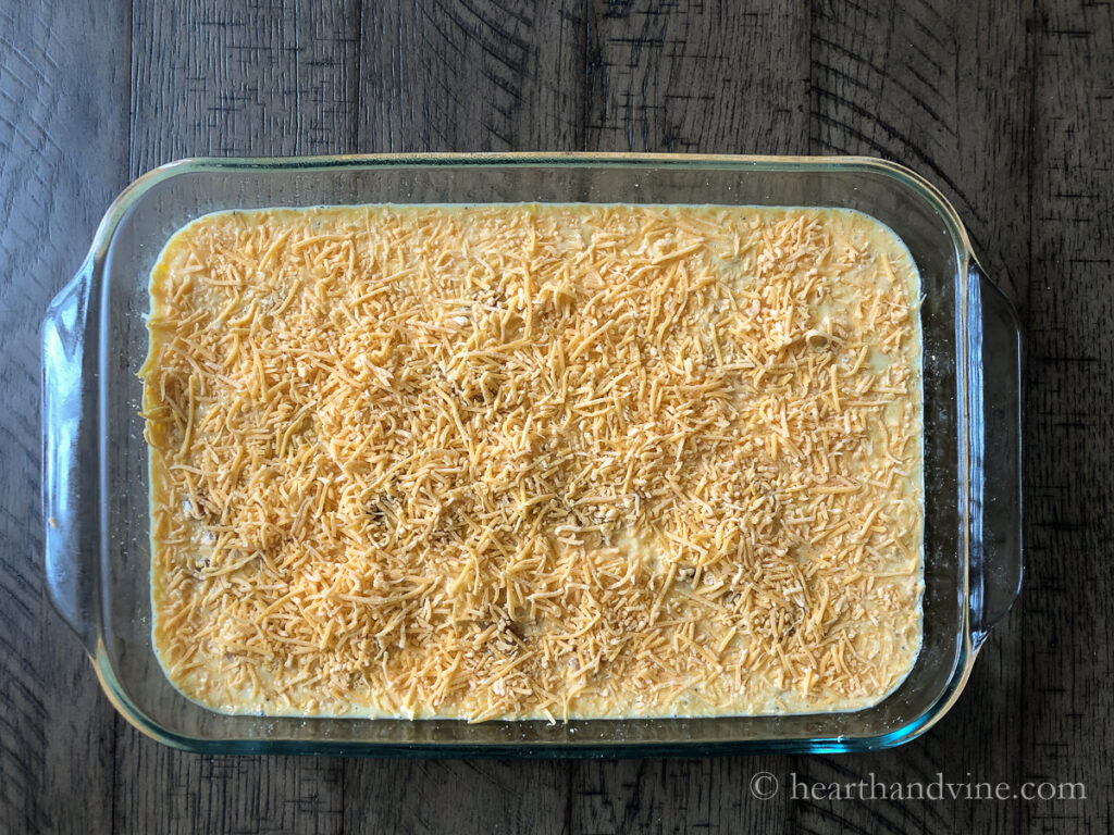 Breakfast biscuit casserole ready to bake in a glass 9 x 13 inch baking pan.