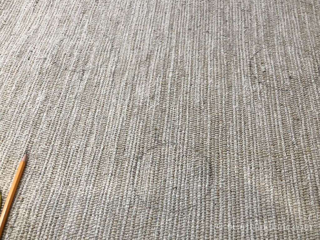 Several small circles in pencil on a rug.