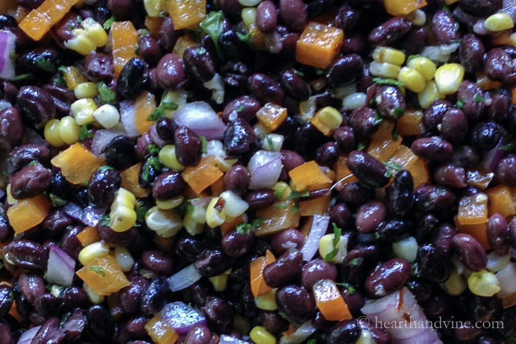 Close up view of black bean salad with peppers, corn, onions and cilantro.