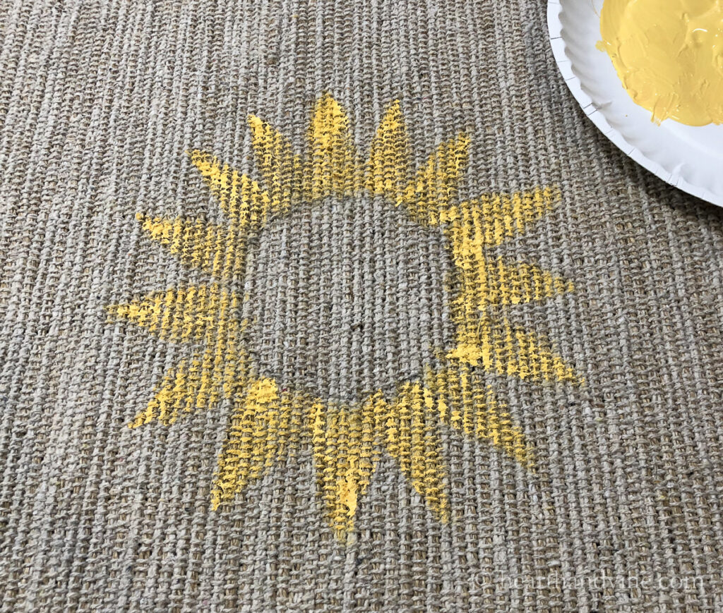 Yellow paint in triangles around a circle to mimic petals.