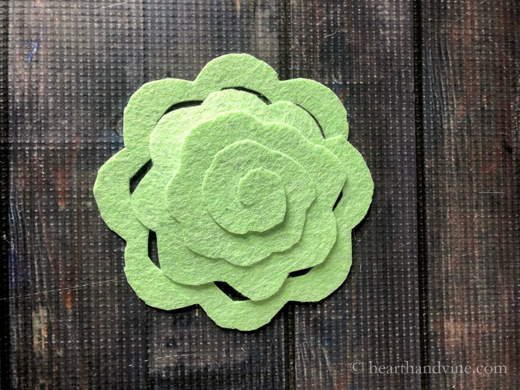 Rounded flower shape in green felt with a spiral cut from the outside edge to the center.