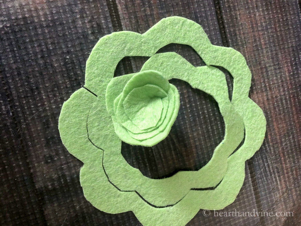 The center of a flower shaped felt cut out starting to wrap into a flower shape.