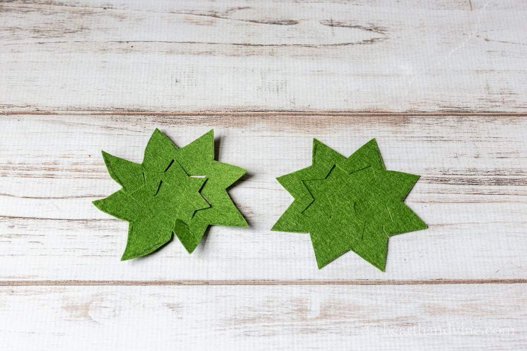 Two green felt cut outs cut into spiral shapes.