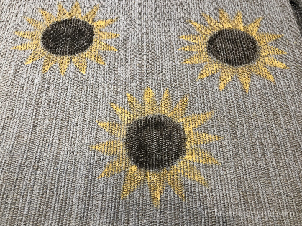 Painted sunflowers on a rug.