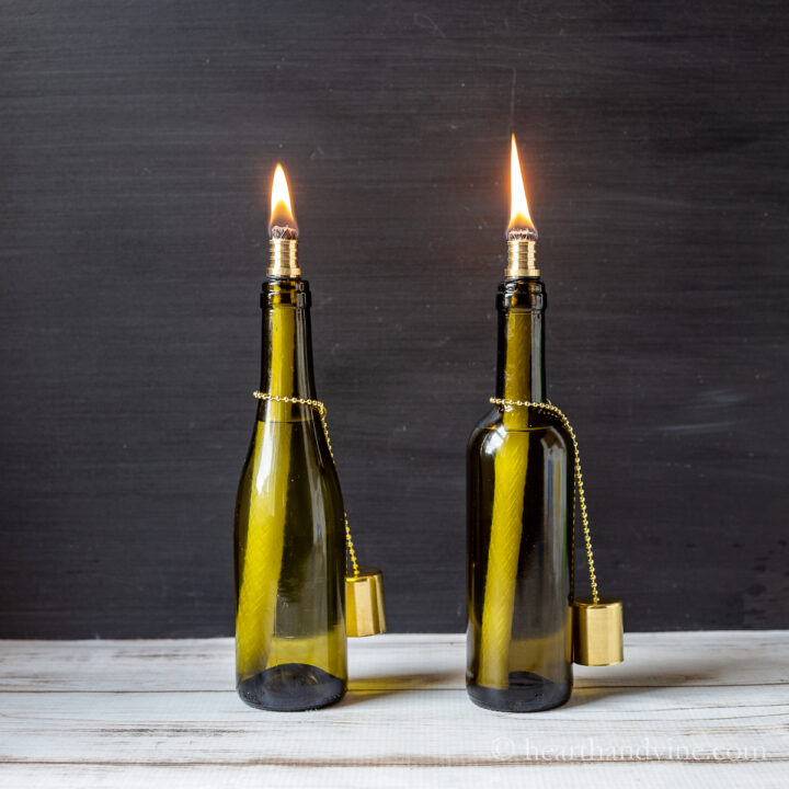 Two tiki torch wine bottles lit with flames.