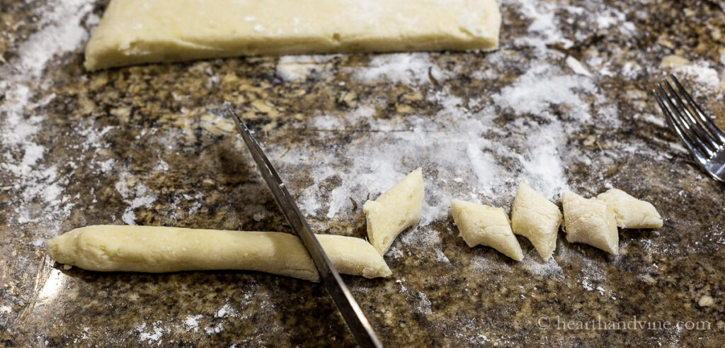 Rolling out dough and cutting bite sized pieces for gnocchi.