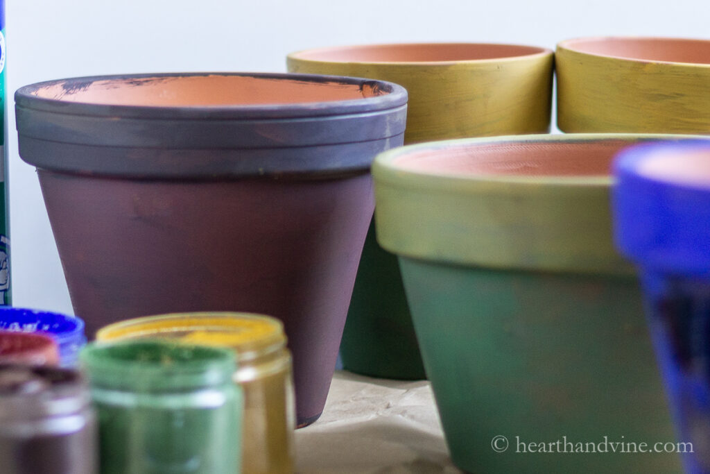 Jars of pigment powder and clay pots painted with the pigments.
