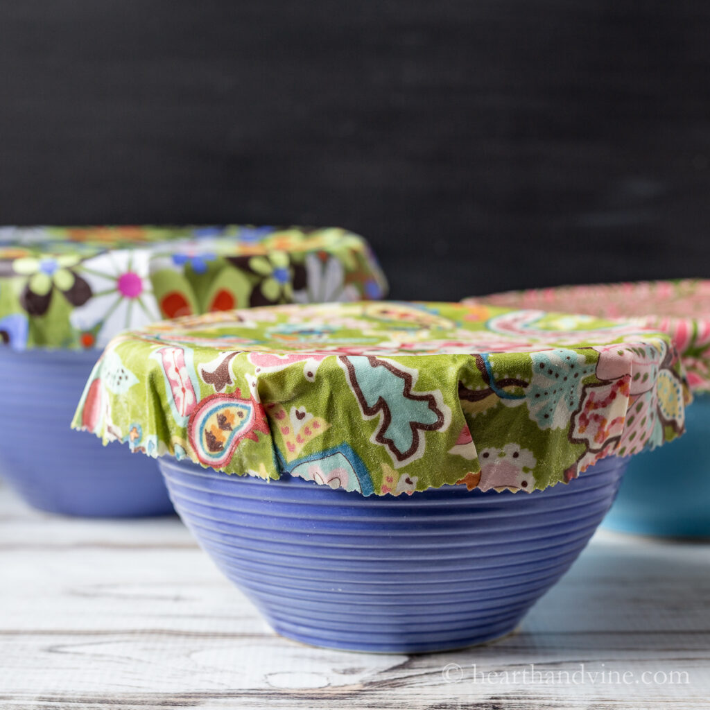 Tree bowls covered with colorful diy beeswax wraps.