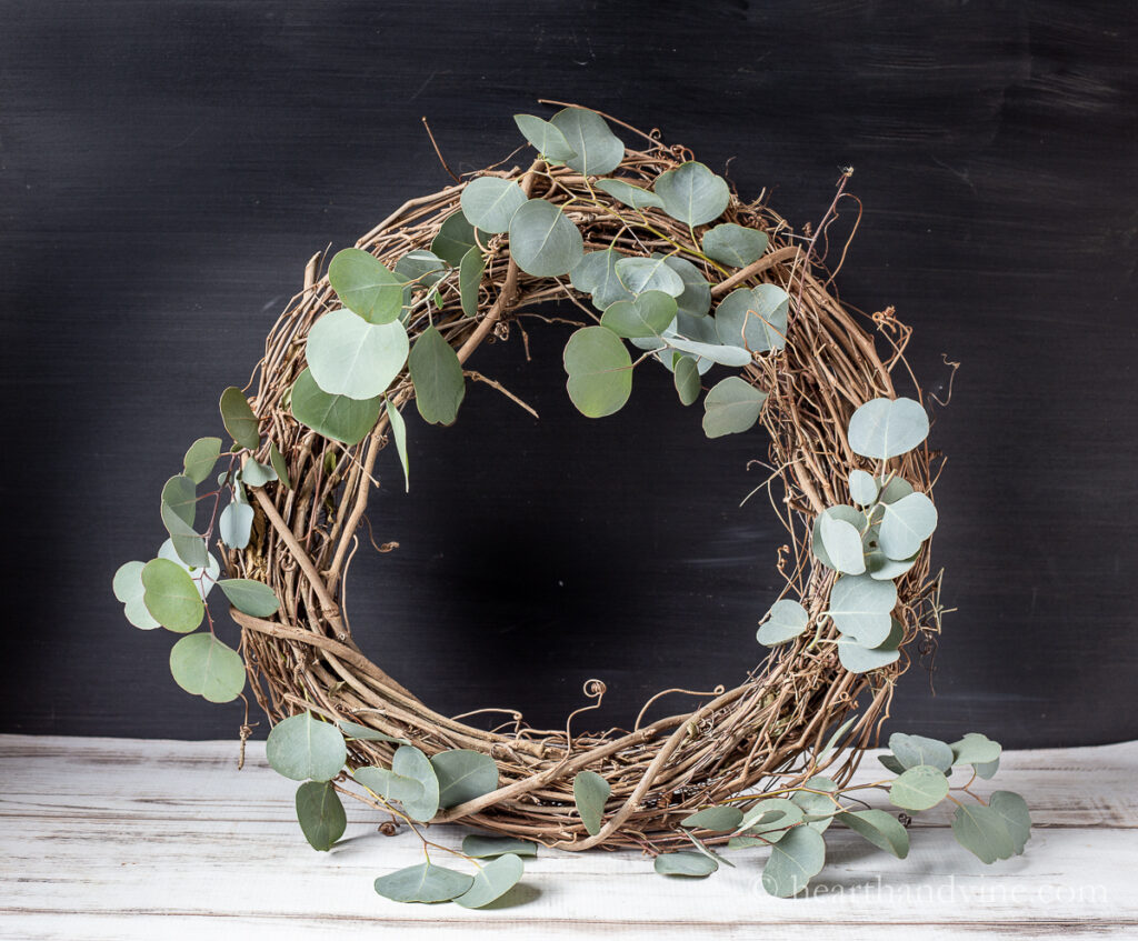 Grapevine wreath with some silver dollar eucalyptus branches placed around the wreath.