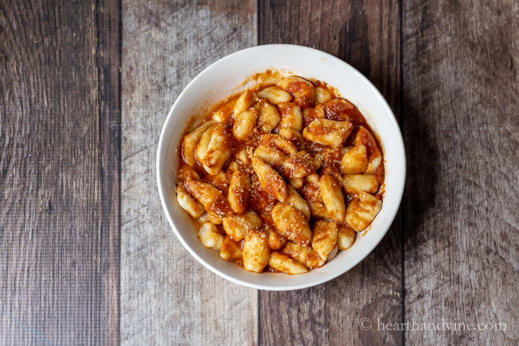 Serving of homemade potato gnocchi with red sauce and parmesan cheese.