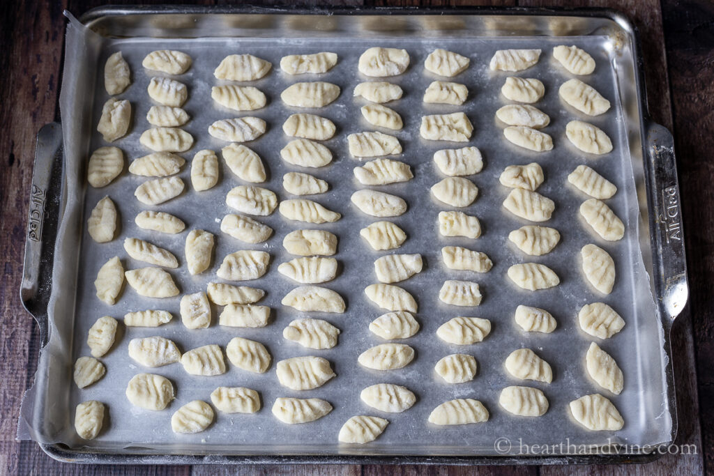 Individual gnocchi on wax paper on a baking sheet.
