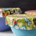 Colorful beeswax wraps on blue ceramic bowls.