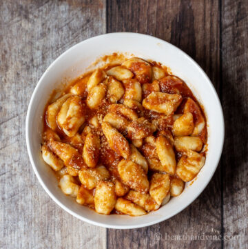 Bowl of homemade gnocchi with red sauce.