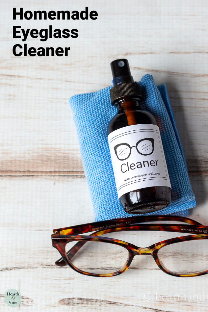 Bottle of homemade eyeglass cleaner on a microfiber cloth and a pair of glasses.