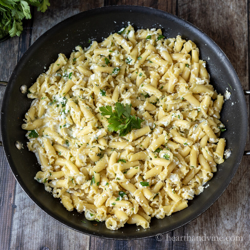 Large saute pan filled with pasta and a lemon ricotta sauce.