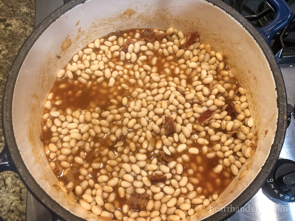 Homemade baked beans with dried soaked and simmered navy beans added to sauce before baking.