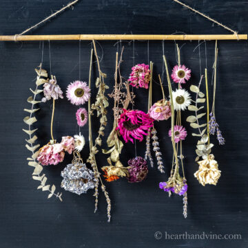 Dried flowers hung from a dowel rod.