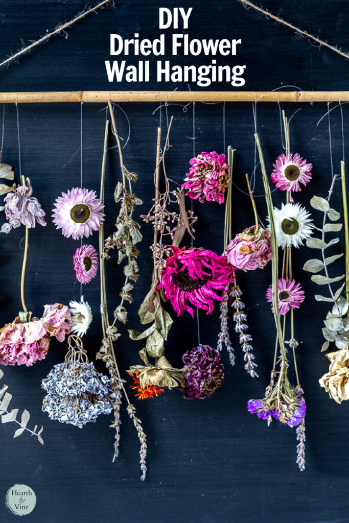 Close up of a dried flower hanging from a dowel rod with a twine hanger.