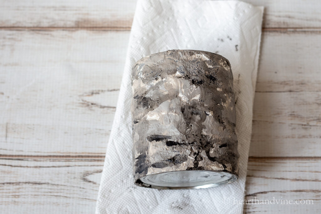 Plaster of Paris can with layers of gray and black paint.