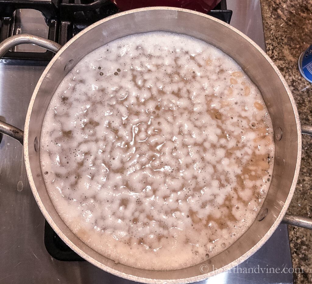 Navy beans simmering in water on the stove.