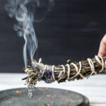 Smudge stick smoking above a clay plate.