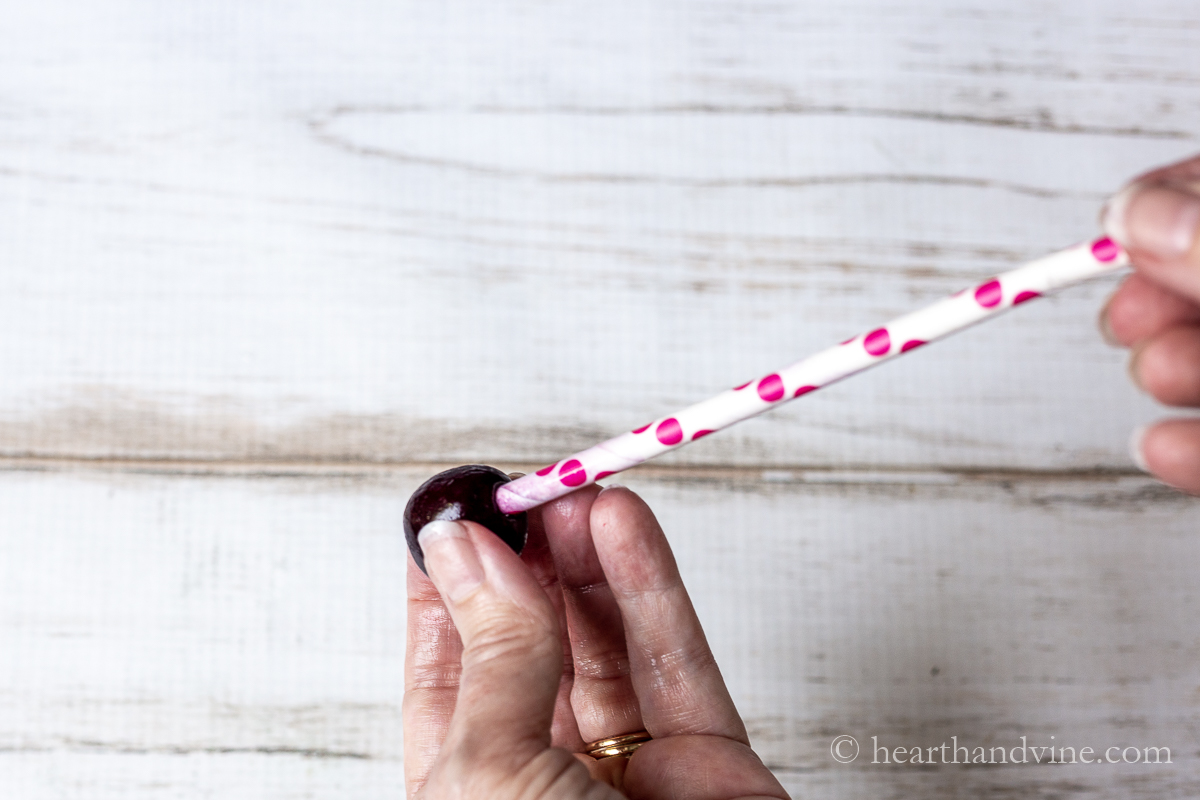 Using a straw to push the pit out of a cherry.