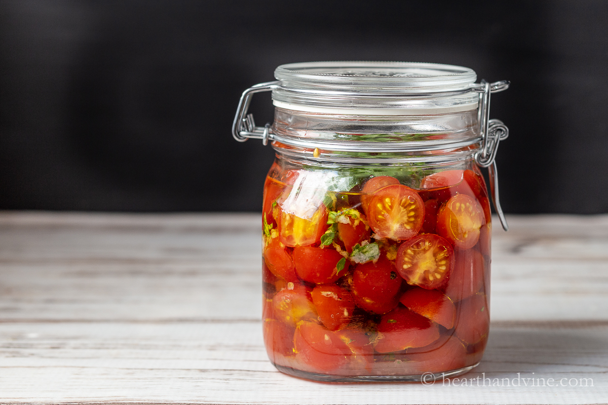 Large air-tight jar of marinated tomatoes.