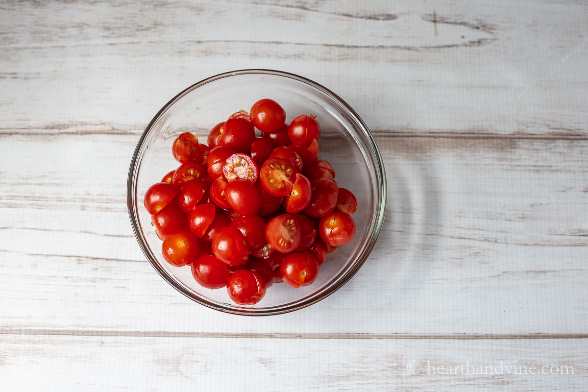 Bowl of cherry tomatoes cut in half.