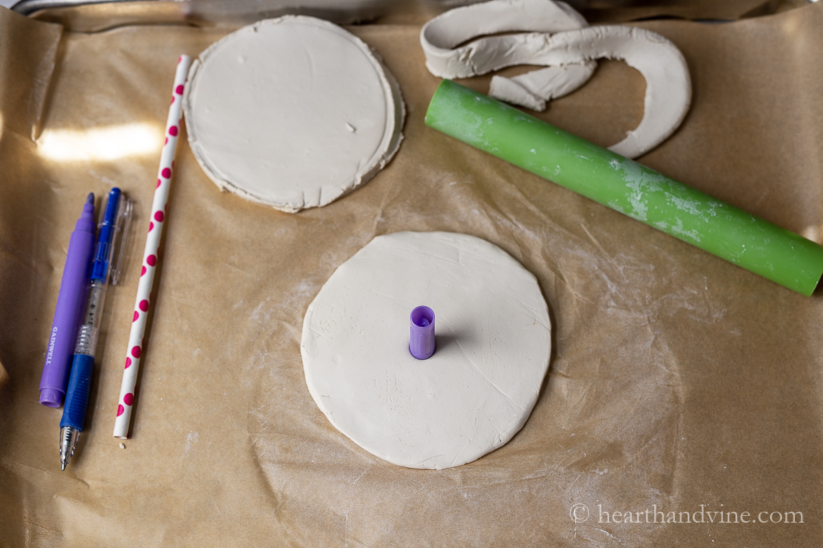 A purple marker cap piercing out the center of a round of clay.