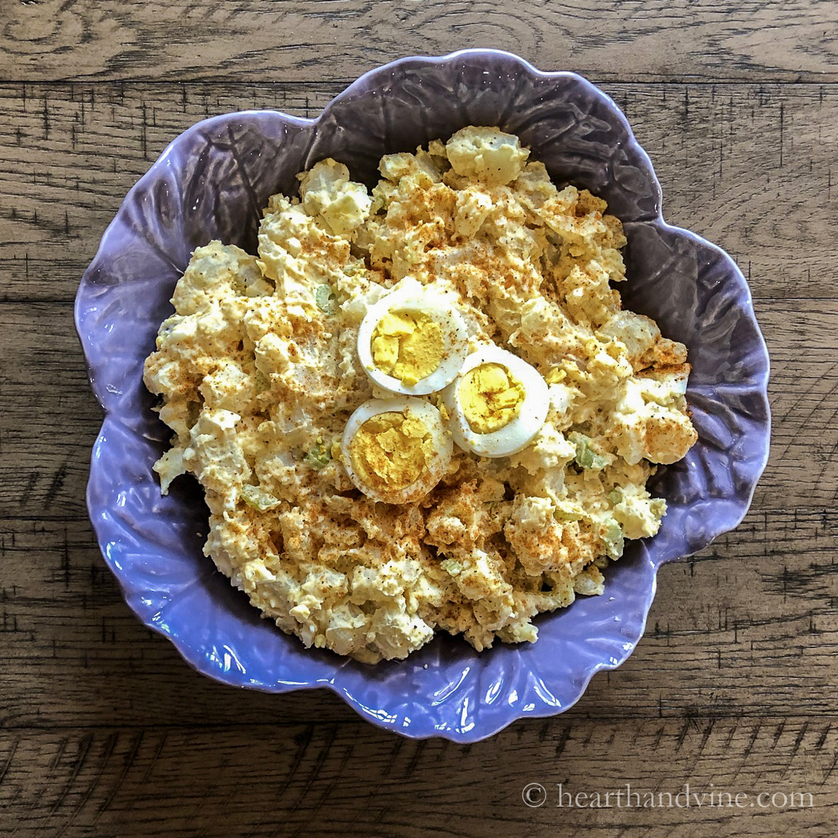 Old fashioned potato salad with sliced egg on top.