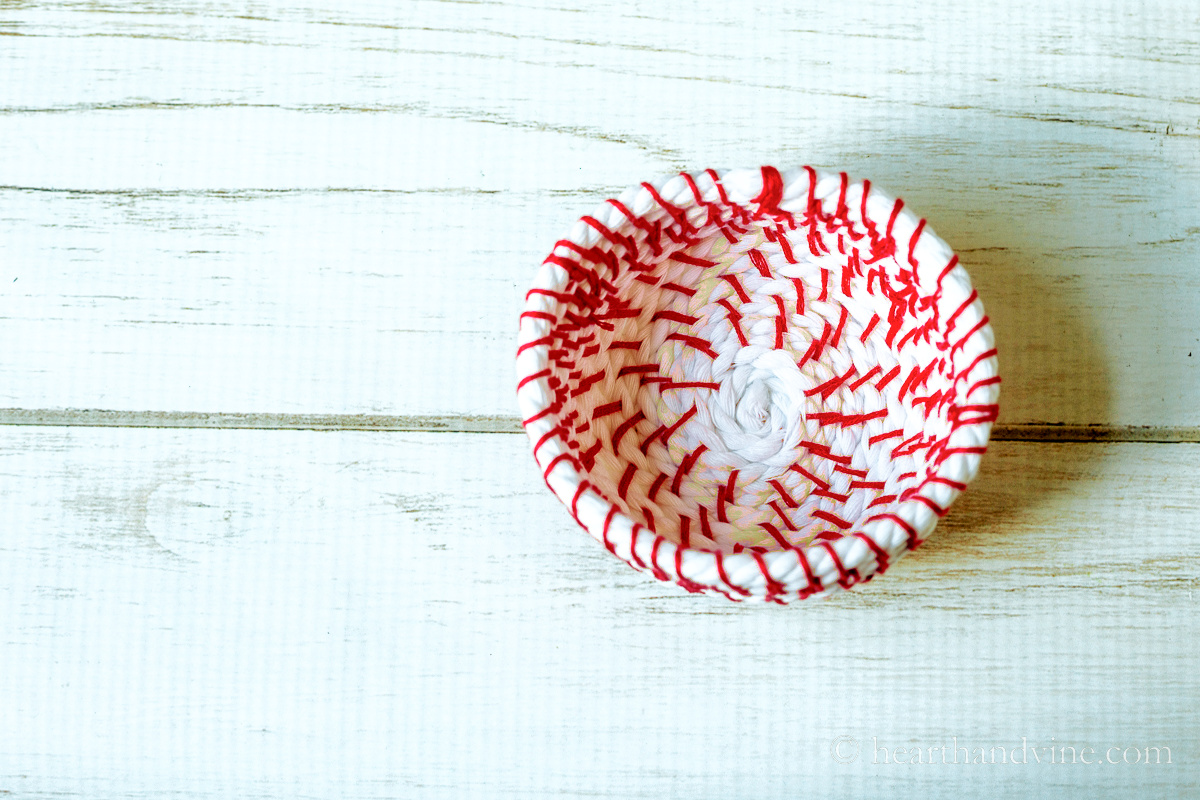 Aerial view of a white rope and red embroidery floss basket.