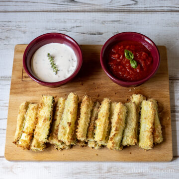 Zucchini fries with cups of ranch dressing and marinara sauce.