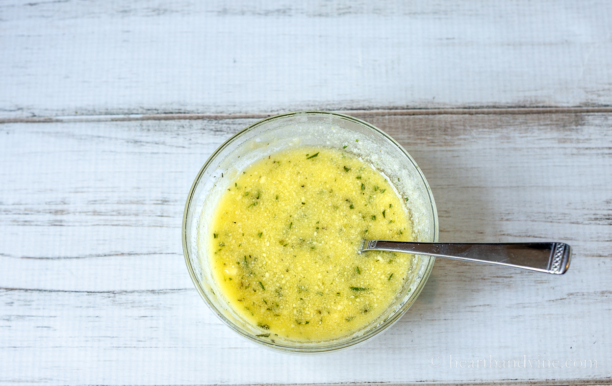 Small bowl of melted butter, olive oil, Parmesan cheese and spices.