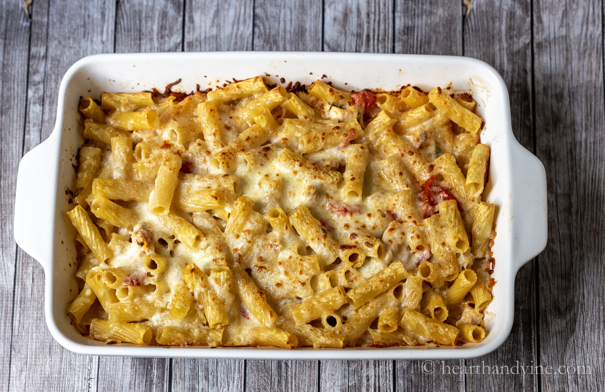Large ceramic baking dish with chicken, pasta and cheese baked until golden brown.