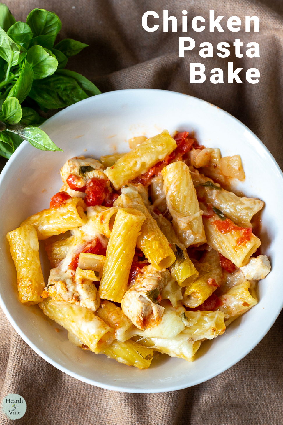 Individual white serving bowl of chicken and rigatoni baked dinner.