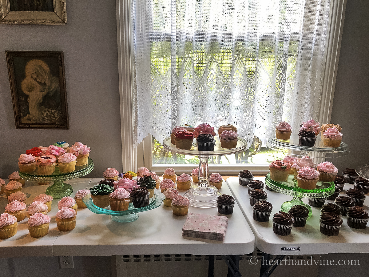 Tables with various cake stands displaying beautiful cupcakes.