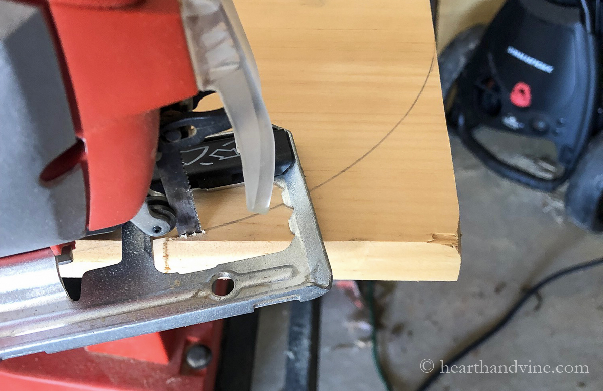Jigsaw cutting a rounded edge of wood board.