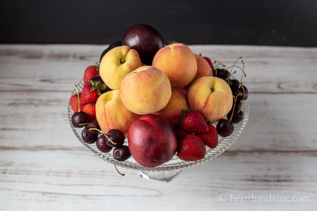 Aerial view of various summer fruit on a cake stand.