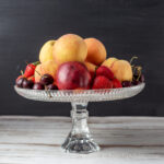 Glass cake stand filled with fruit.