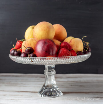 Glass cake stand filled with fruit.