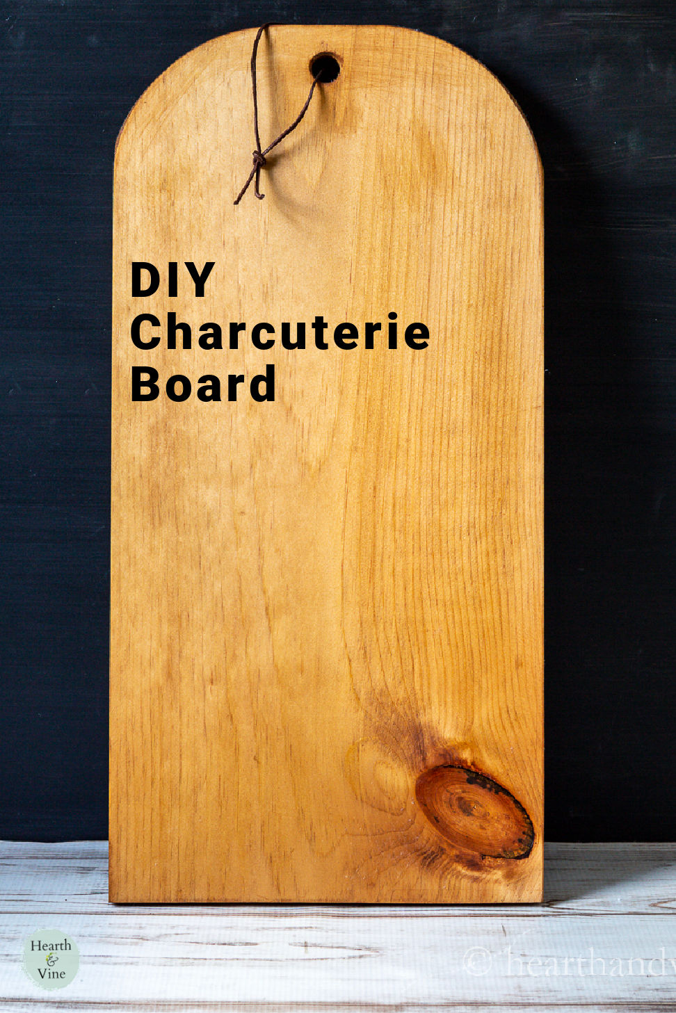 Large handmade charcuterie board with a rounded edge and hole for hanging.