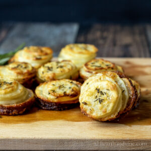 Crispy potato stacks on a wood board after baking.